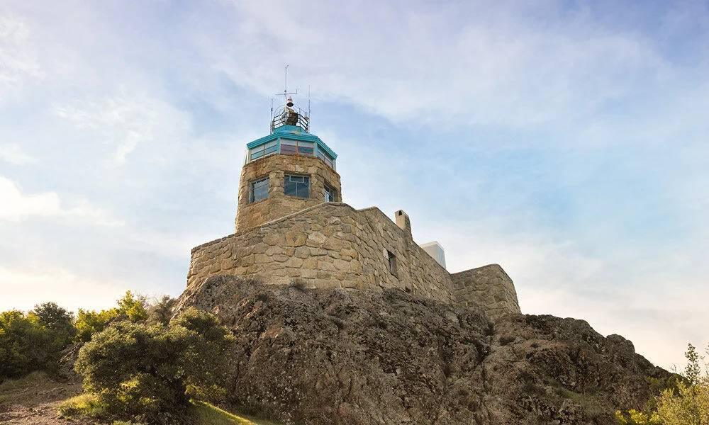 Stone observation tower perched on a rocky hill in Walnut Creek, California, overlooking surrounding greenery under a clear sky.