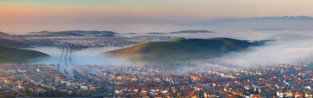 Panoramic aerial view of San Ramon CA residential neighborhoods and misty hills