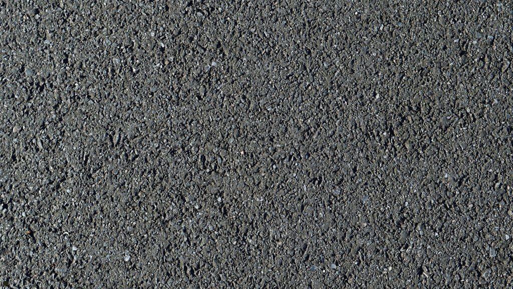 Close-up view of a porous blacktop asphalt pavement surface in need of early fall sealcoating protection.